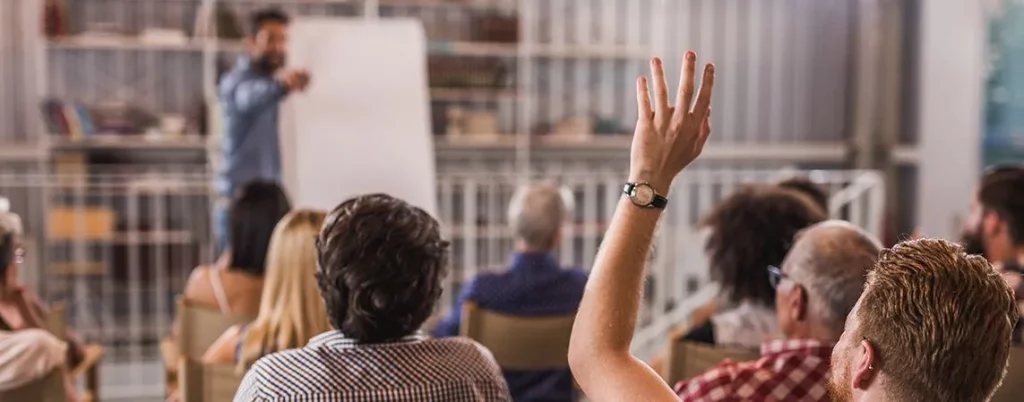 iemand steekt zijn hand op bij een evenement