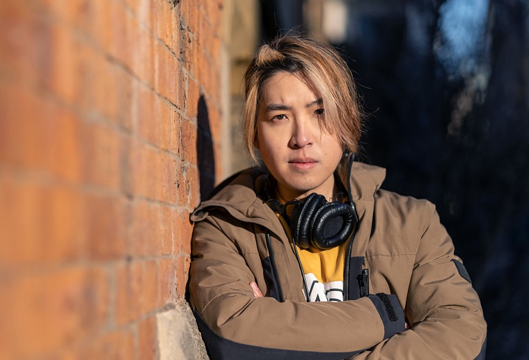 Volwassen man met koptelefoon leunend tegen een buitenmuur