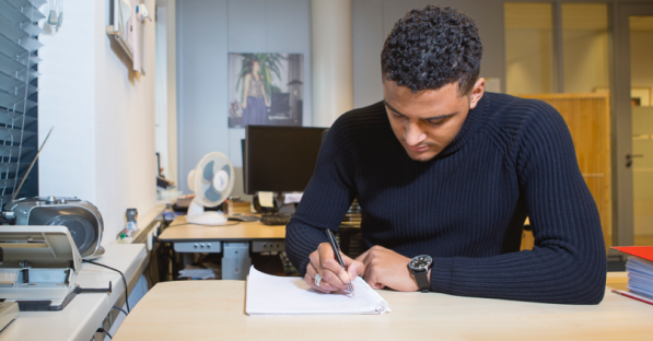 Man zit in zijn werkkamer en maakt notities